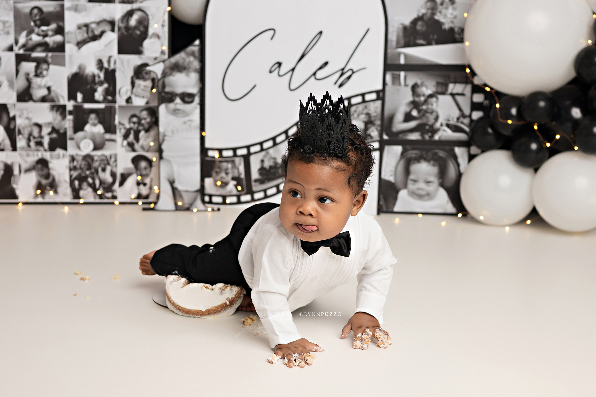 Custom Photo Cake Smash Session featuring baby boy in black and white tux with personalized photo backdrop